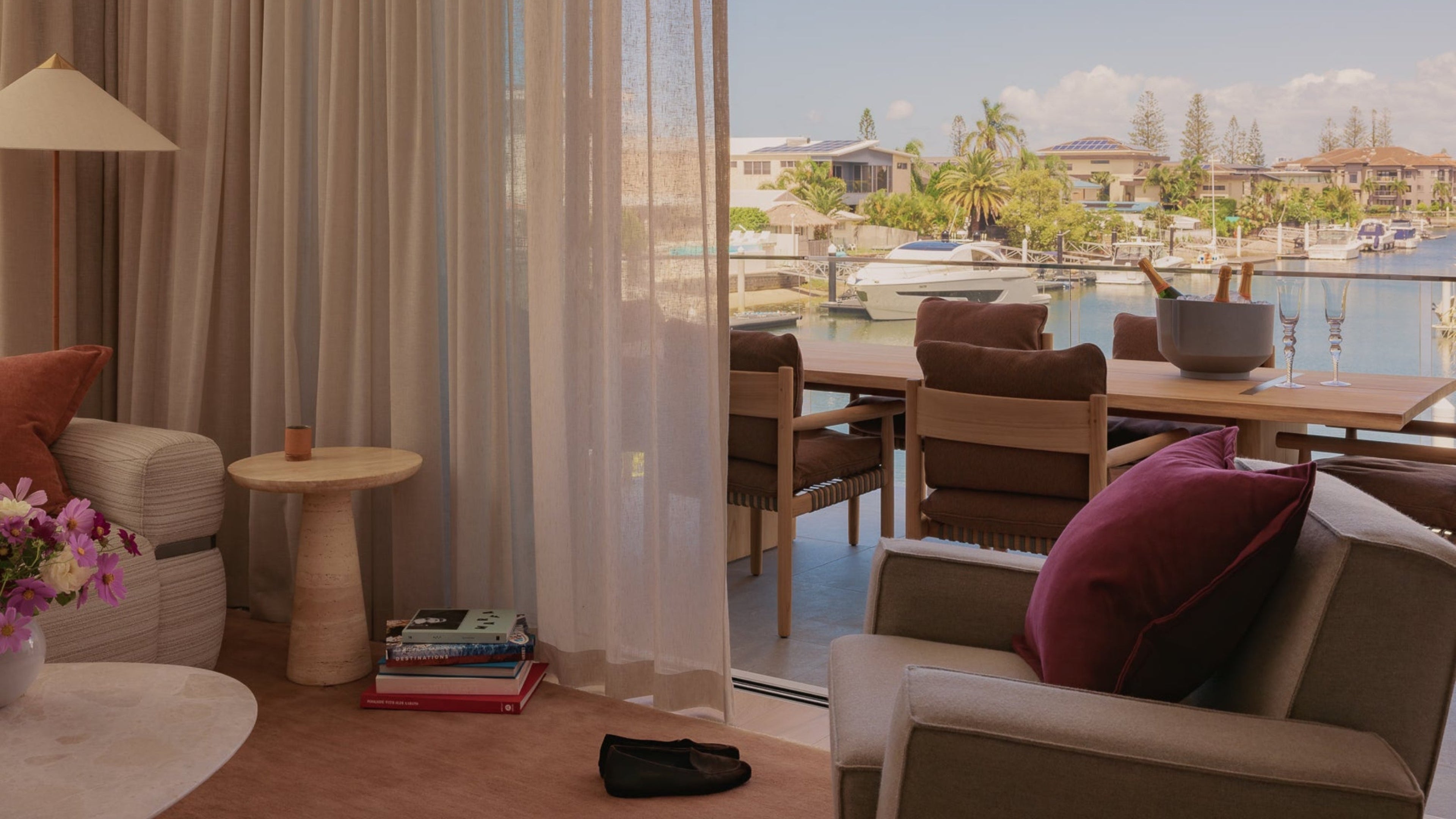 Living room with a view of a marina through large windows.